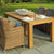 Wooden outdoor dining table with wicker chairs on a stone patio