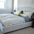 Neatly made bed with decorative pillows in a well-lit bedroom.
