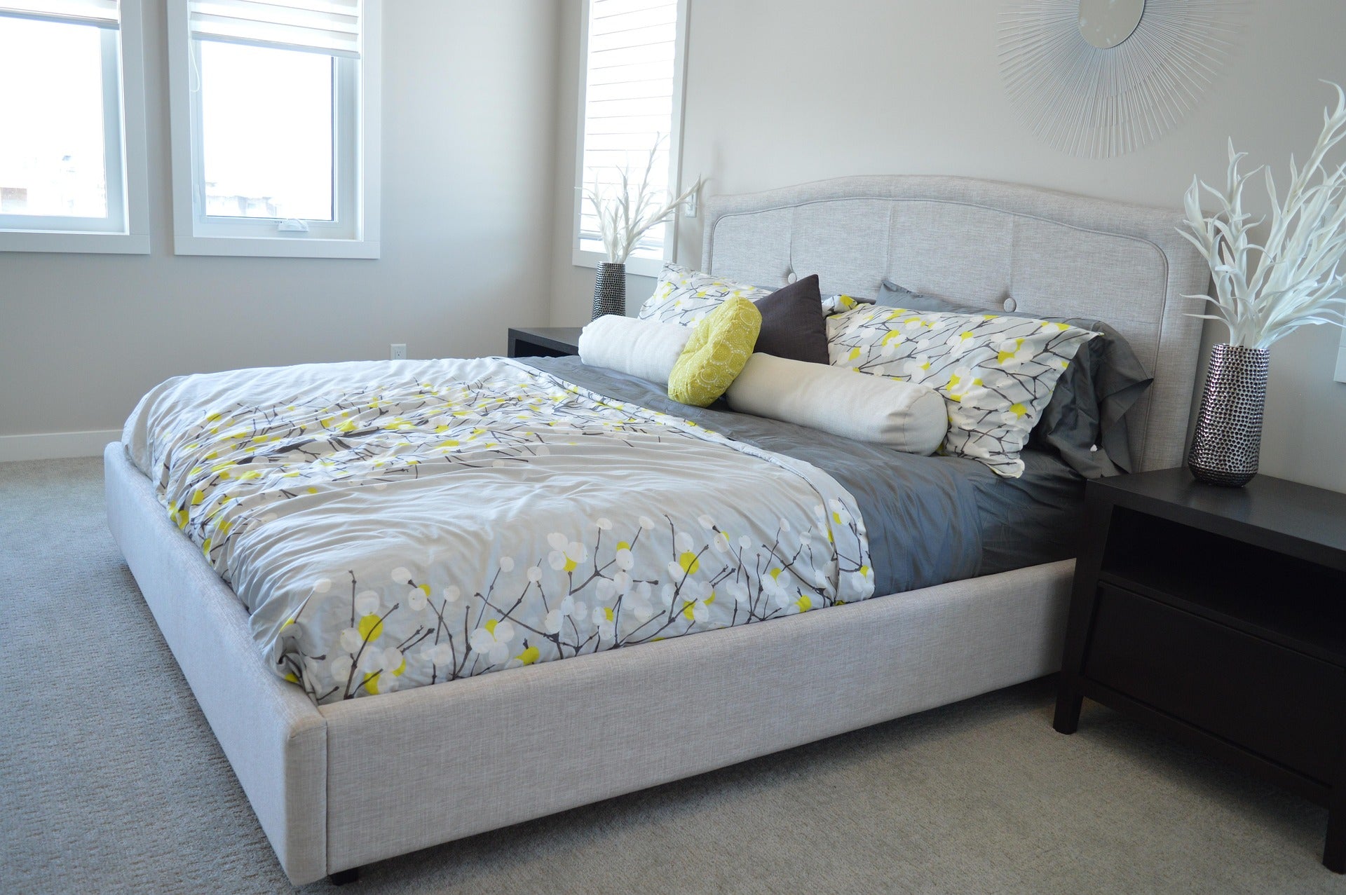 Neatly made bed with decorative pillows in a well-lit bedroom.